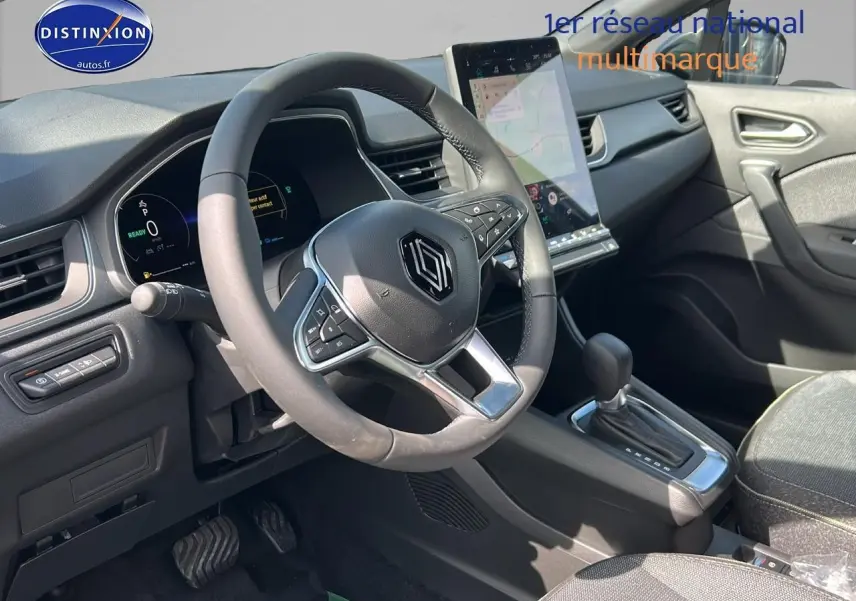 Intérieur Renault Captur 1.6 e-tech hybride 2025 vu côté conducteur, volant multifonction et écran tactile vertical.