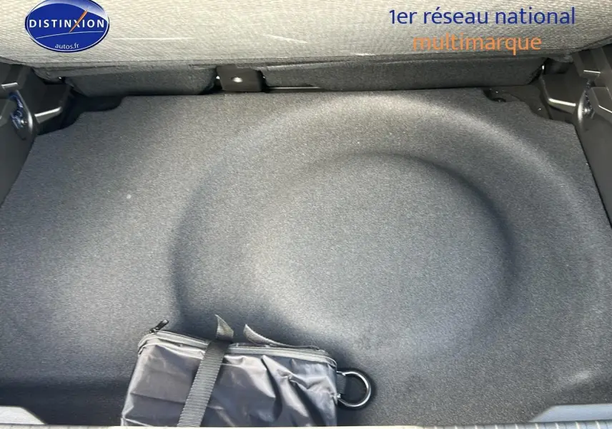 Coffre ouvert d'un Renault Captur noir Étoile 2025, vue plongeante sur la roue de secours et une trousse noire.