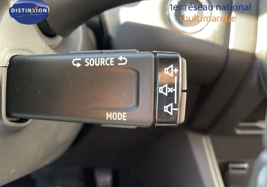 Gros plan sur la commande audio au volant du Renault Captur gris Rafale Métal avec toit noir, version hybride 2025.