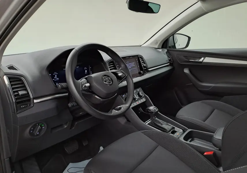Vue intérieure côté conducteur du Skoda Karoq 2023, tableau de bord moderne avec Digital Cockpit et console centrale noire.