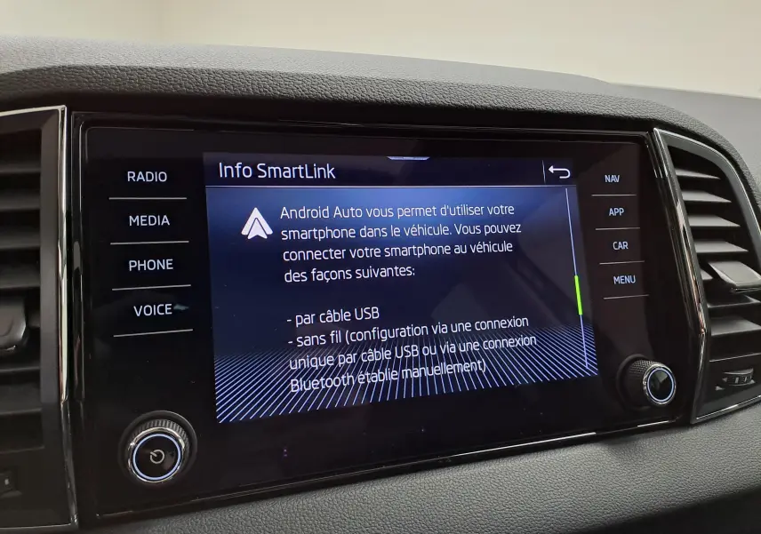 Écran tactile central du Skoda Karoq 2023 affichant les options Android Auto, entouré de commandes noires et finition grise.