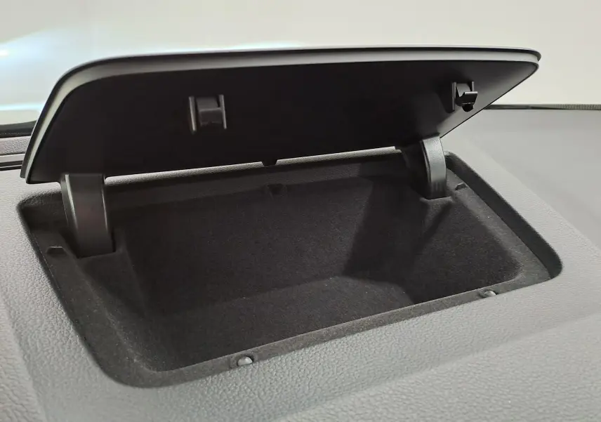 Gros plan sur la boîte de rangement ouverte intégrée au tableau de bord du Skoda Karoq 2023 gris perle.
