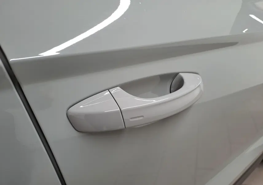 Poignée de porte côté gauche du SKODA KAROQ gris perle 2023, vue rapprochée sur la finition lisse et brillante.