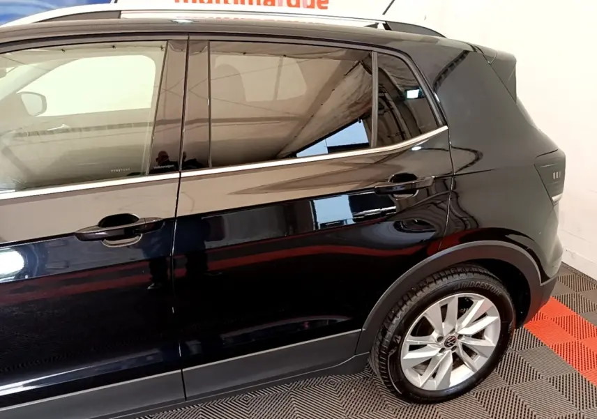 Vue latérale côté droit du Volkswagen T-Cross noir, mettant en valeur les jantes alliage et les vitres teintées.