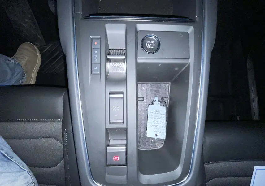 Vue plongeante sur la console centrale noire du Citroën C5 Aircross hybride 2025 avec bouton start et sélecteur de mode de conduite.