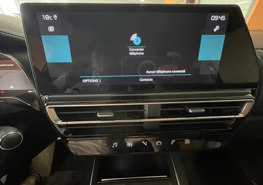 Vue rapprochée de l’écran tactile central du Citroën C5 Aircross hybride gris platinium, affichant la connexion téléphone.
