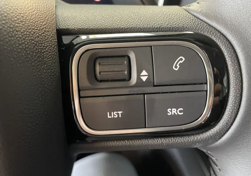 Gros plan sur les boutons de commande au volant du Citroën C5 Aircross Hybride gris platinium, côté gauche.