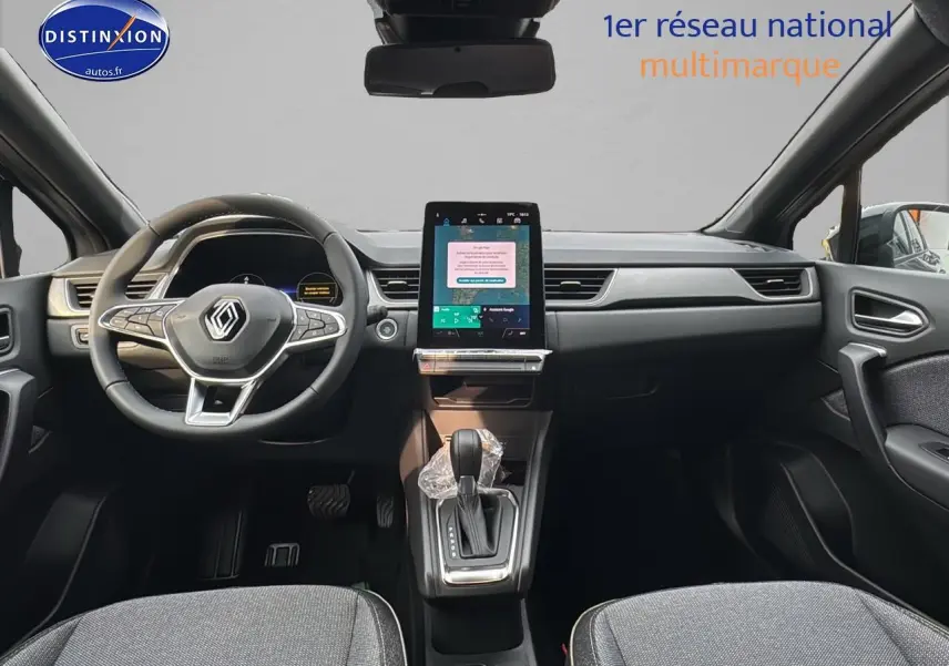 Intérieur avant du Renault Captur gris cassiopée 2025 avec écran tactile vertical et volant multifonction.