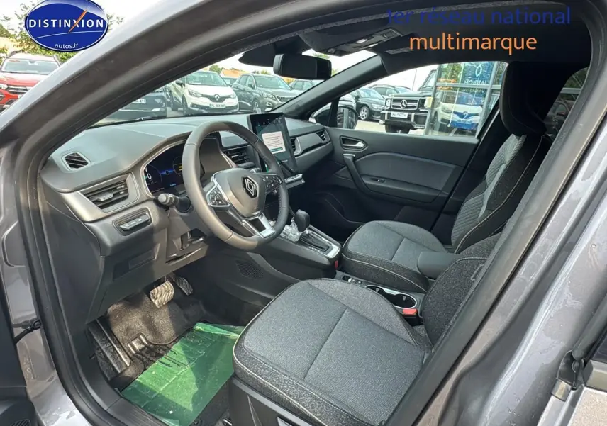 Intérieur avant droit du Renault Captur gris cassiopée 2025 avec sièges tissu gris et tableau de bord moderne.