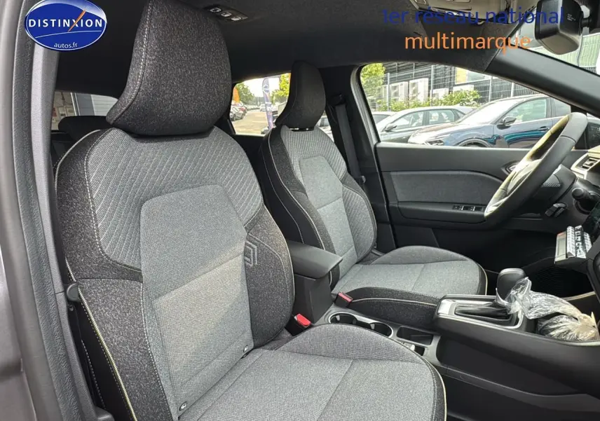 Intérieur avant du Renault Captur gris cassiopée 2025, sièges tissu gris et console centrale avec boîte auto.