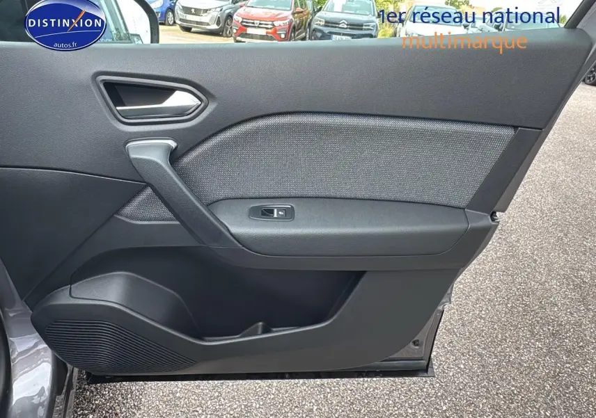 Porte côté gauche ouverte du Renault Captur gris cassiopée, mettant en valeur la garniture intérieure noire et la commande de vitre.