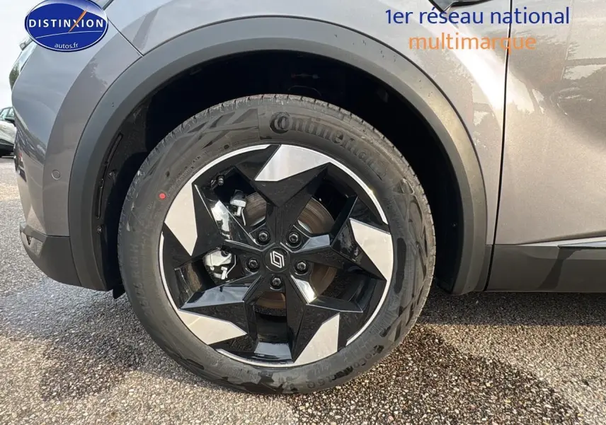 Gros plan sur la roue avant gauche du Renault Captur gris cassiopée avec jante alu noire et argentée au design étoilé.