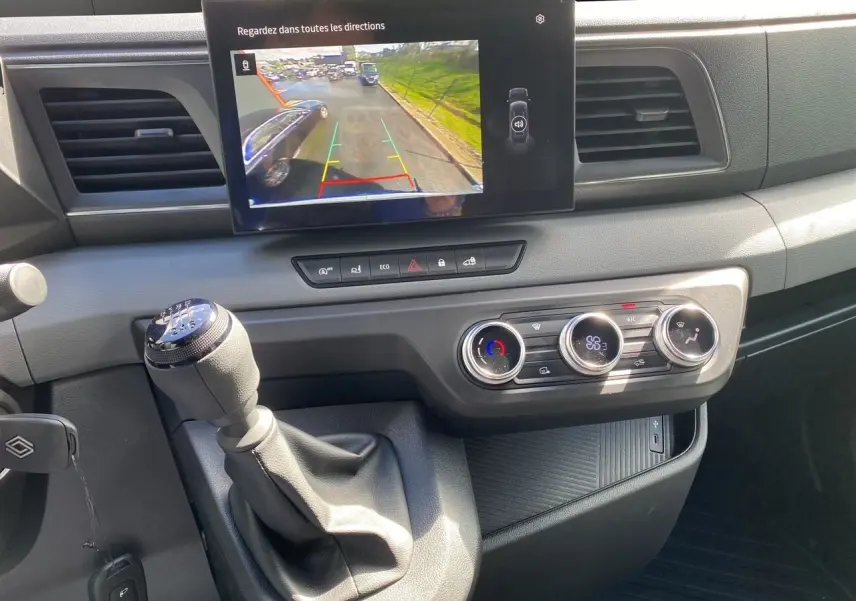Vue rapprochée de la console centrale du Renault Master 2025 avec écran caméra de recul et commandes climatisation.