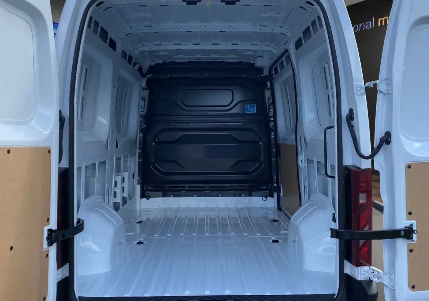 Intérieur du Renault Master blanc 2025 vu de l’arrière avec portes ouvertes et espace de chargement vide et tôlé.
