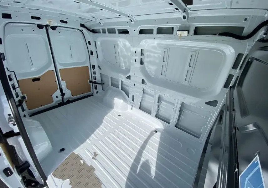 Intérieur du coffre blanc du Renault Master 2025, vue arrière avec portes tôlées ouvertes et plancher métallique.