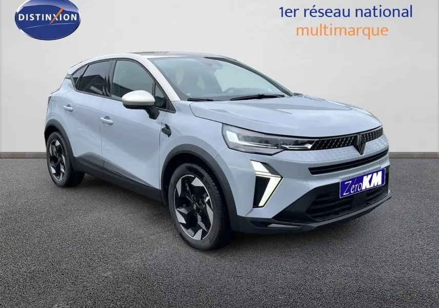 Renault Captur E-Tech hybride 2025 gris Rafale, vue 3/4 avant droit avec jantes noires et toit beige.