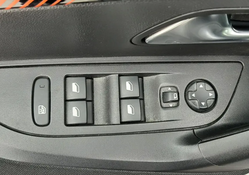 Gros plan sur les commandes de lève-vitres et réglage des rétroviseurs côté conducteur d’un Peugeot 2008 gris Artense.