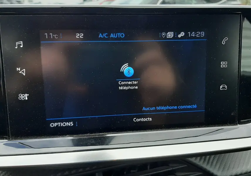 Écran tactile central de la Peugeot 2008 2020 affichant la connexion Bluetooth, avec tableau de bord gris et aérateurs visibles.