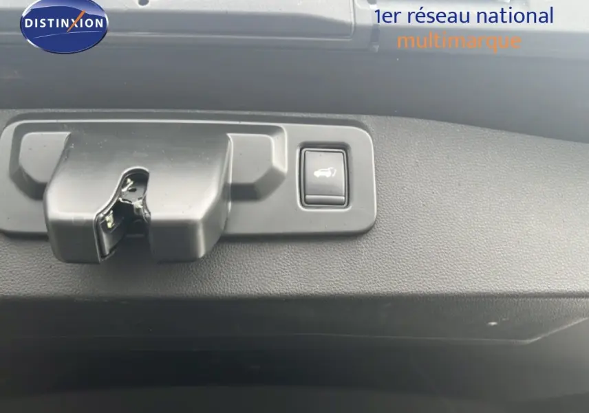 Gros plan sur le mécanisme d'ouverture du hayon avec bouton de déverrouillage, intérieur noir du Renault Symbioz.
