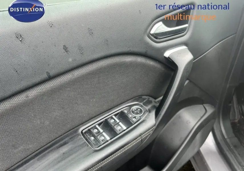 Gros plan sur la porte avant gauche gris cassiopée métal du Renault Symbioz 2025, avec commandes électriques des vitres et poignée noire.