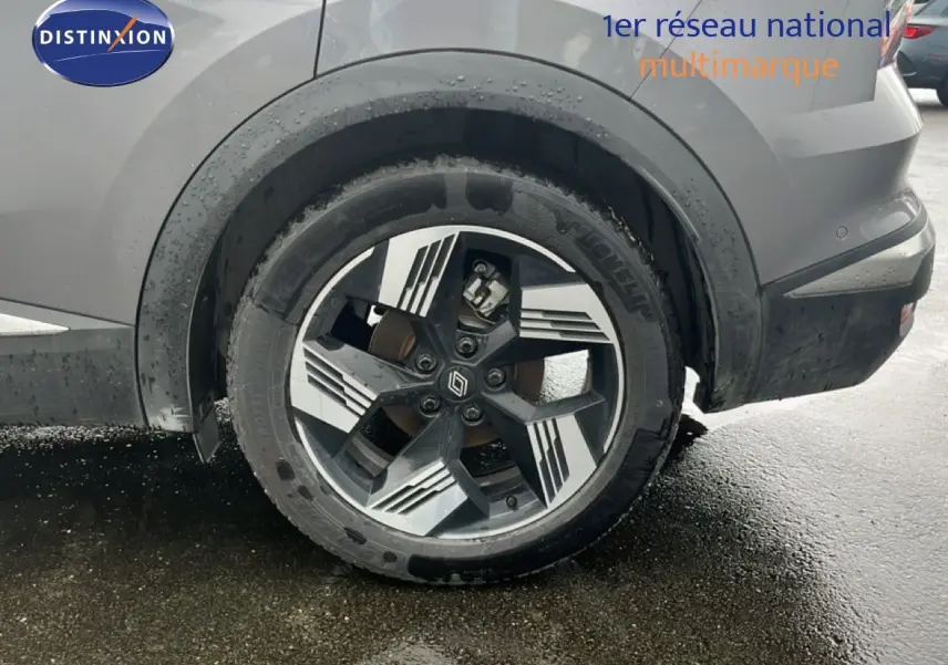 Gros plan sur la roue arrière droite du Renault Symbioz gris cassiopée métal avec jante alliage à motifs géométriques.