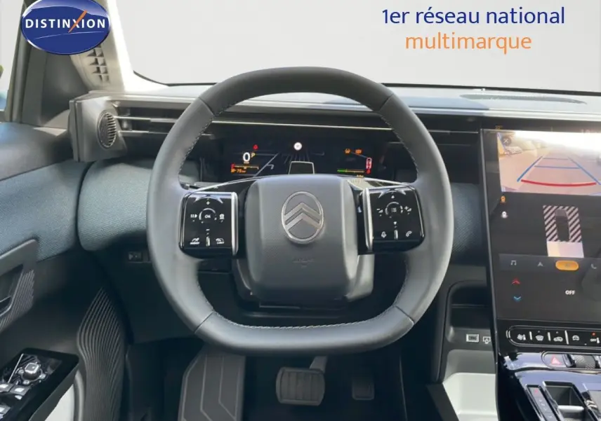 Vue intérieure centrée sur le volant du Citroën C5 Aircross Hybrid 2026 avec tableau de bord numérique et écran tactile.