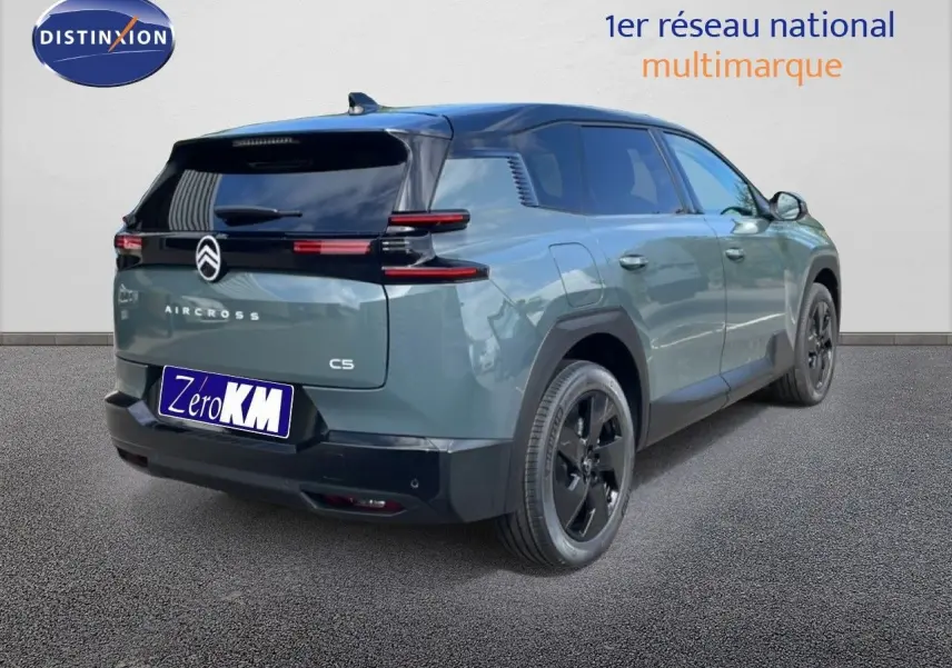 Vue 3/4 arrière droite d'un Citroën C5 Aircross Hybrid 2026 vert Astoria métallisé avec toit noir et jantes noires.