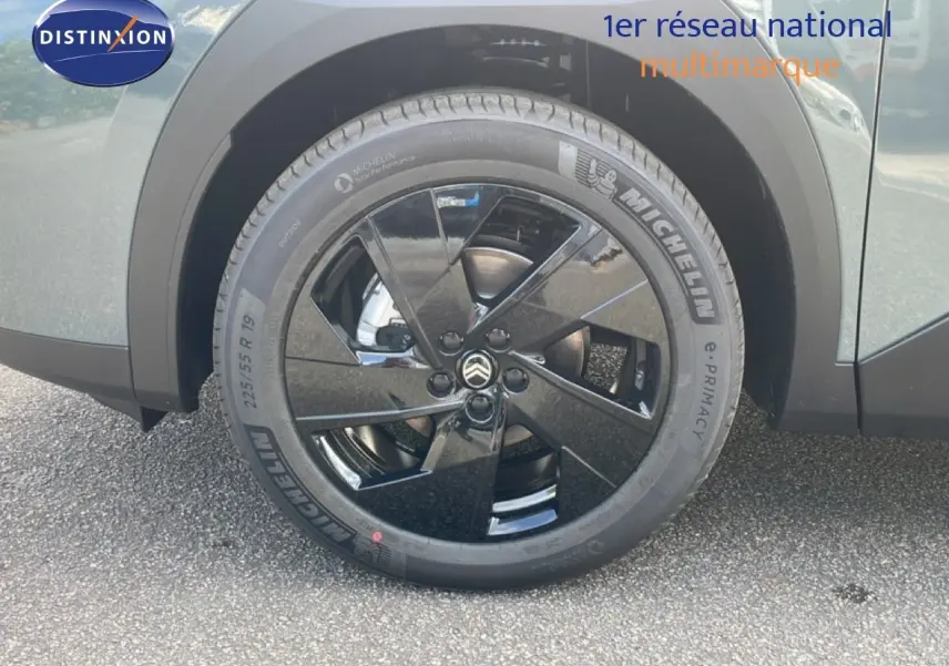 Gros plan sur la roue avant gauche noire brillante du Citroën C5 Aircross Hybrid 2026 vert Astoria Metal.