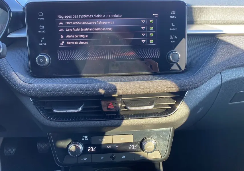 Vue rapprochée du tableau de bord de la Skoda Fabia 2024, écran tactile et commandes de climatisation visibles.