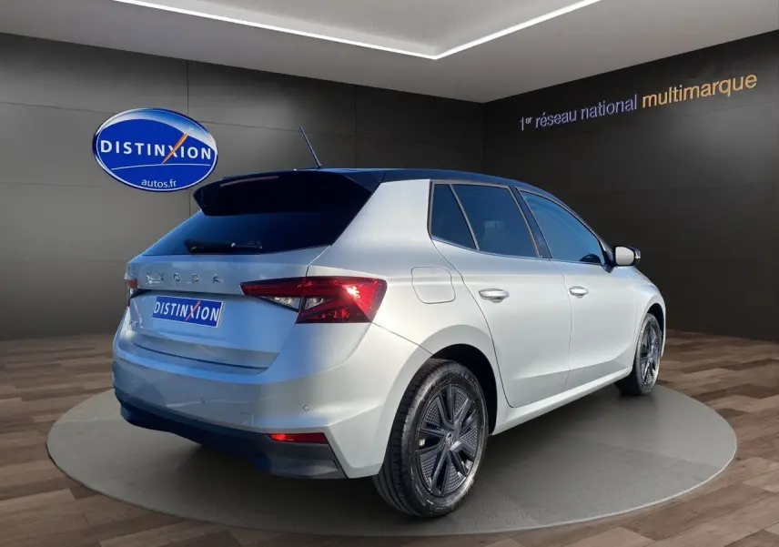 Vue 3/4 arrière droite d'une Skoda Fabia 2024 gris clair avec toit noir et jantes modernes en concession.