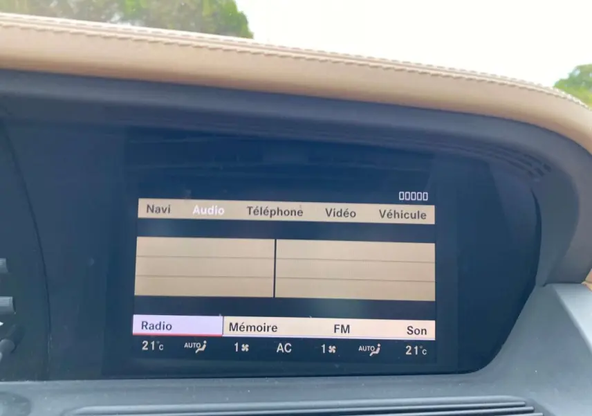 Écran central de la Mercedes Classe S 600 L noir de 2007 affichant le menu audio et la température à 21°C.