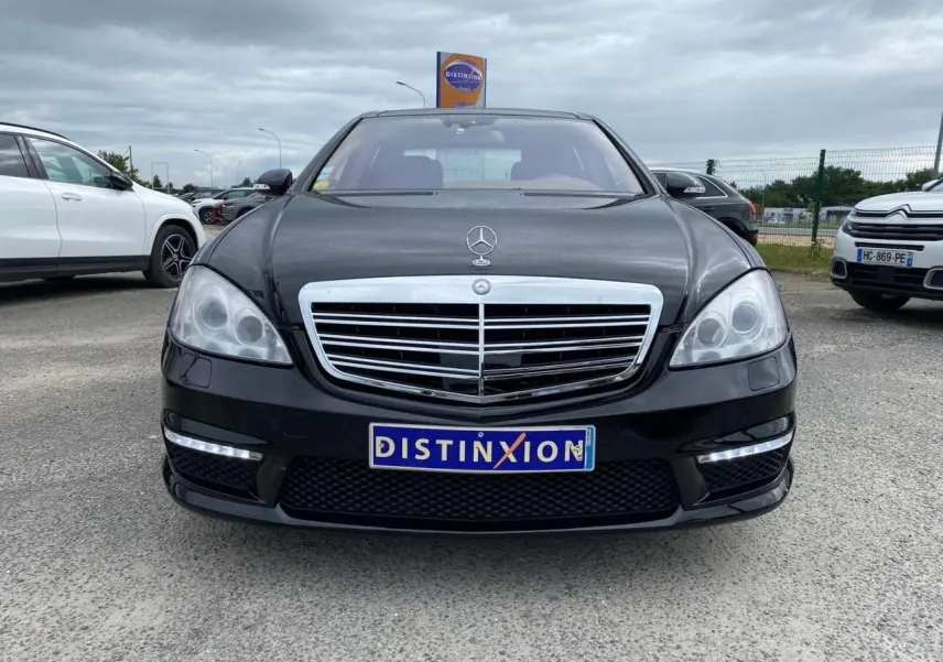Mercedes Classe S 600 L noire vue de face, avec calandre chromée et feux LED diurnes allumés.