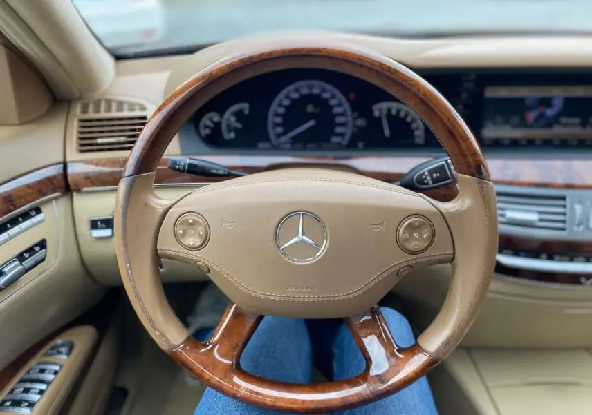 Vue rapprochée du volant en cuir et bois Designo beige de la Mercedes Classe S 600 L de 2007.