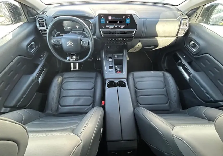 Vue intérieure du poste de conduite du Citroën C5 Aircross 2022, avec sièges cuir noirs et tableau de bord moderne.