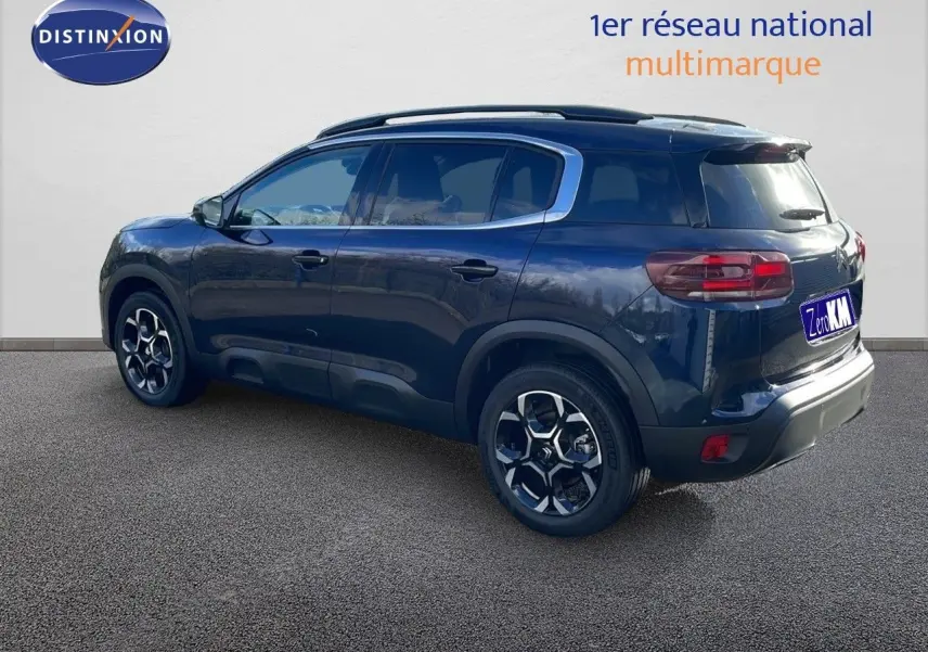 Vue latérale droite d'un Citroën C5 Aircross bleu Eclipse Metal, SUV compact avec jantes alliage et barres de toit.