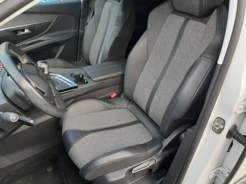 Vue rapprochée côté conducteur de l'intérieur du Peugeot 3008 blanc nacré, siège tissu et cuir gris avec console centrale.