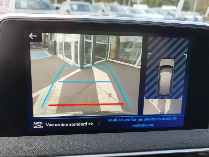 Affichage de la caméra de recul du Peugeot 3008 blanc nacré, montrant l'arrière avec lignes de guidage et vue 360° du véhicule.