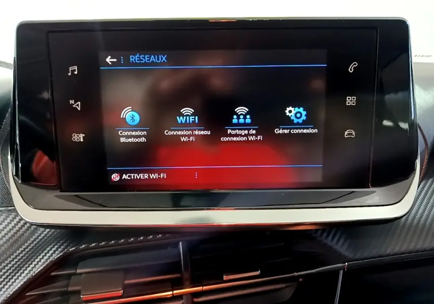 Écran tactile central du tableau de bord du Peugeot 2008 gris clair, affichant les options de connexion réseau Wi-Fi et Bluetooth.