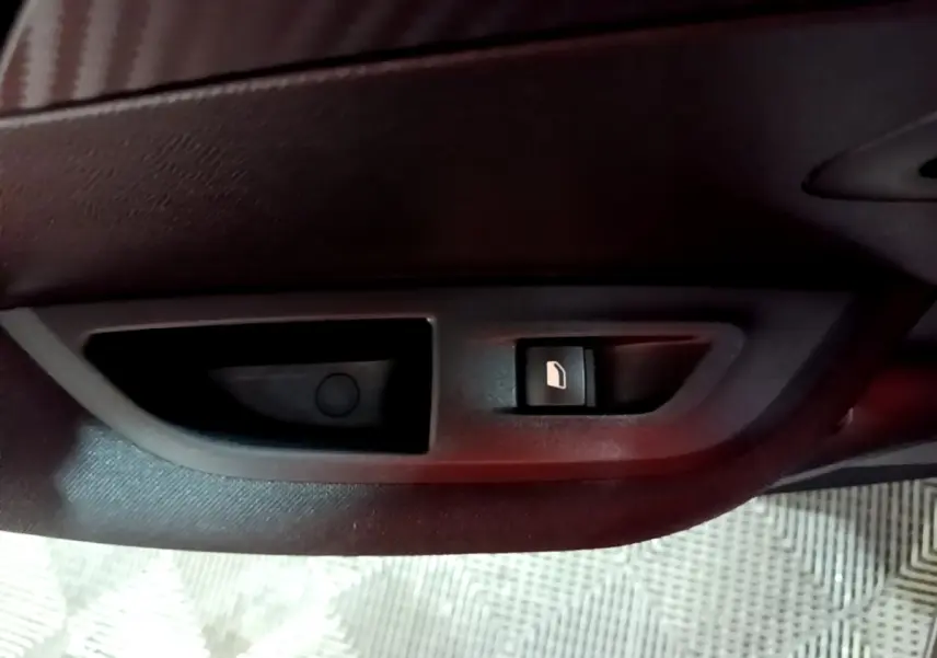 Gros plan sur la commande de verrouillage des portes côté intérieur d'une Peugeot 2008 gris clair, version Active Business.