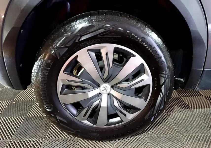 Gros plan sur la roue avant droite d’un Peugeot 2008 gris clair, avec jante alliage et pneu Continental.