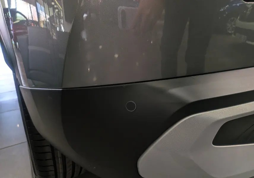 Détail du pare-chocs arrière gris Mercury du Citroën C3 Aircross hybride 2026 avec capteur de stationnement visible.