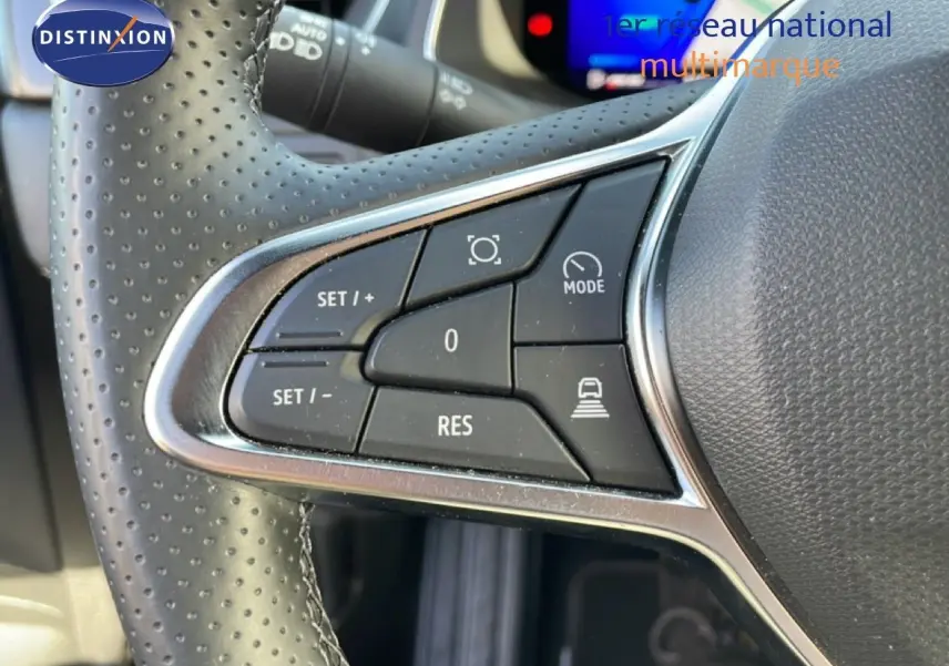 Gros plan sur les commandes au volant à gauche du Renault Symbioz 2025, cuir perforé et boutons de régulateur de vitesse.