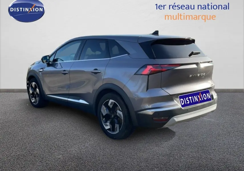 Renault Symbioz gris cassiopée métal en 3/4 arrière droit, SUV hybride avec feux arrière LED et jantes bicolores.