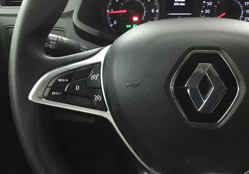 Gros plan sur le volant noir du Renault Express Van 2021, avec commandes de régulateur de vitesse et logo Renault central.