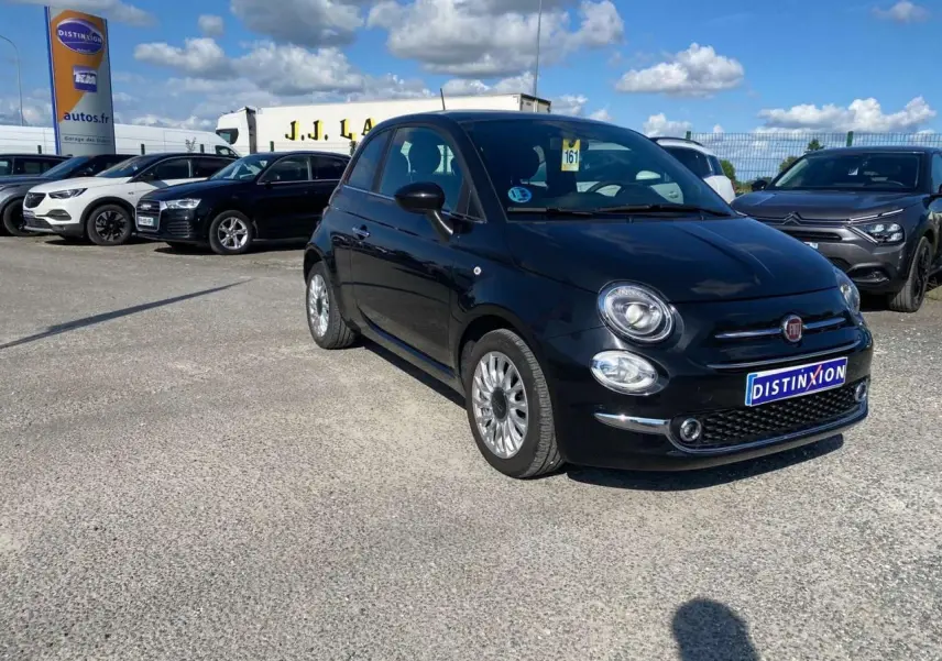 Fiat 500 noire vue en 3/4 avant droit, avec jantes alliage 16'' Spider, stationnée sur un parking extérieur.