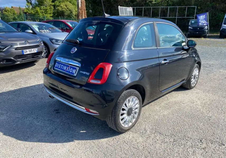 Fiat 500 noire vue 3/4 arrière droit, avec jantes alliage et toit vitré panoramique fixe.