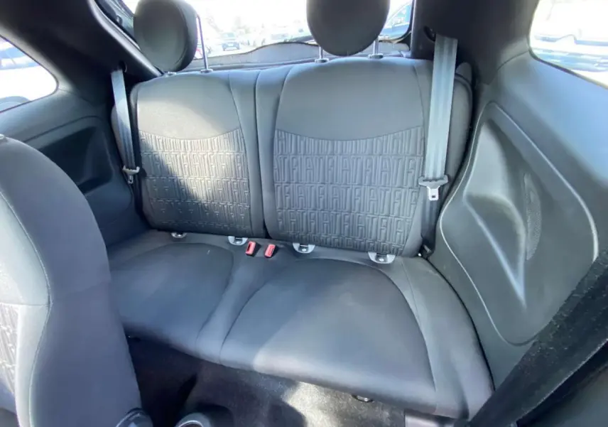 Vue intérieure arrière de la banquette noire de la Fiat 500 2024 avec motifs FIAT embossés sur les dossiers.