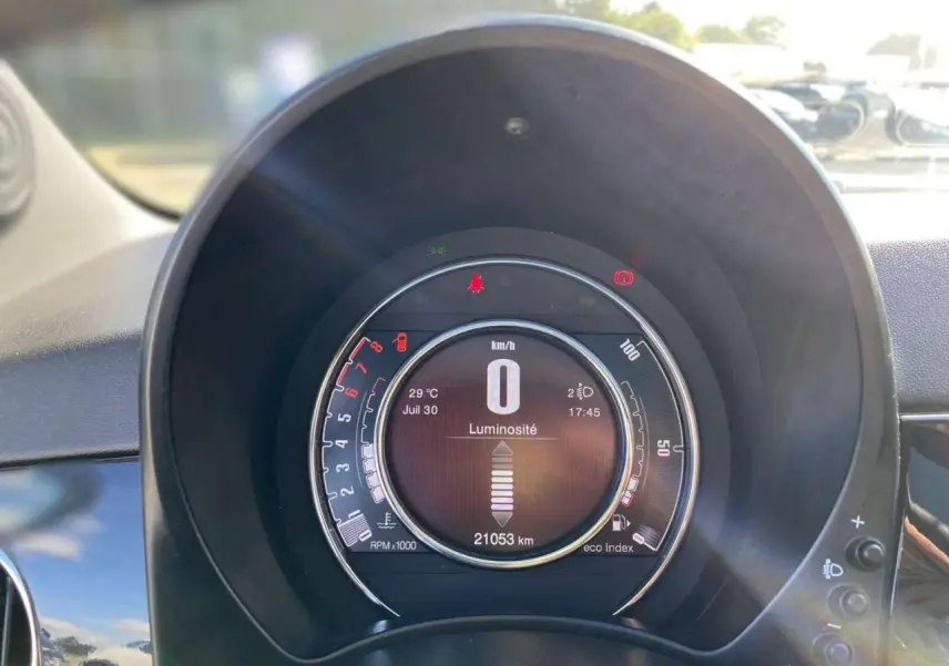 Vue rapprochée du tableau de bord numérique du Fiat 500 noir 2024 affichant la vitesse à zéro et l'odomètre à 21053 km.