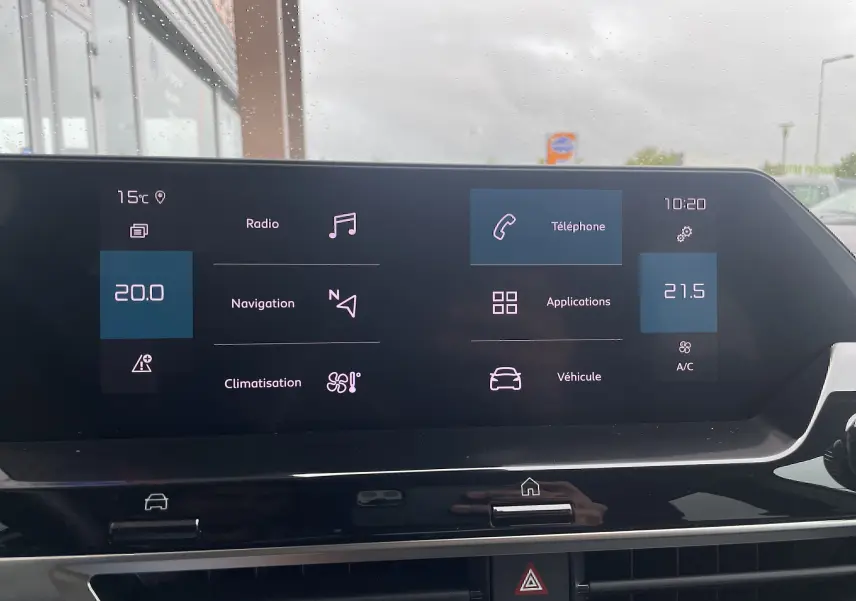Écran tactile central de la Citroën C4 blanche 2022 affichant radio, navigation, téléphone et climatisation.