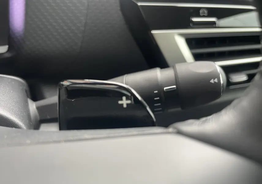 Gros plan sur la commande de palette de changement de vitesse "+" côté droit du volant d'une Citroën C4 blanche 2022.